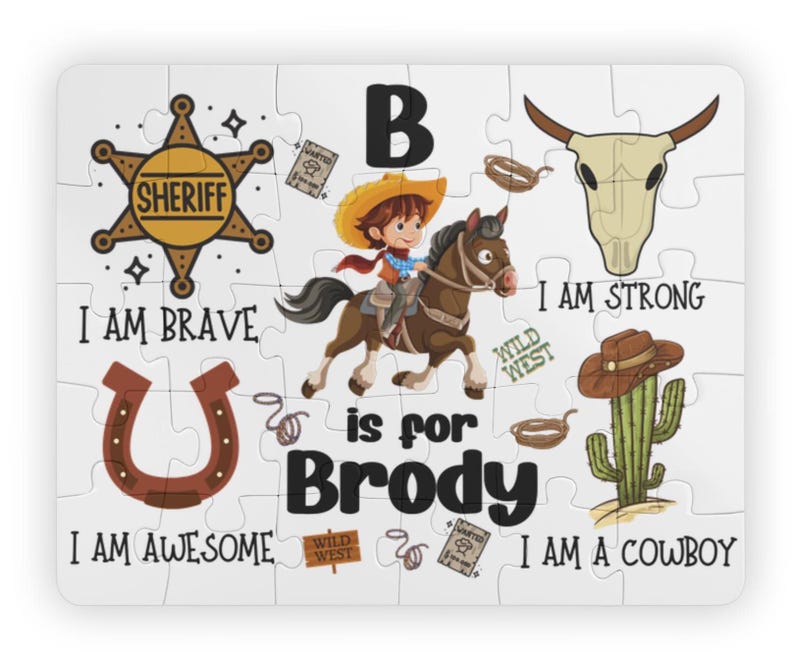 May include: A white jigsaw puzzle with a cowboy theme. The puzzle features a sheriff's badge, a horseshoe, a steer skull, and a cactus. Text includes "I AM BRAVE", "I AM AWESOME", "I AM STRONG", and "I AM A COWBOY". The name "Brody" is also featured.