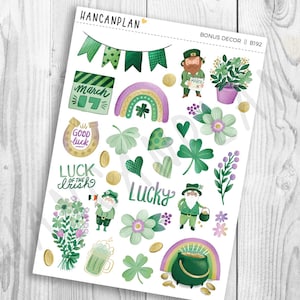 May include: A sheet of St. Patrick's Day themed stickers with various illustrations. Includes shamrocks, rainbows, leprechauns, pots of gold, and the text "Luck of the Irish" and "Lucky". The color palette features green, purple, gold, and white.