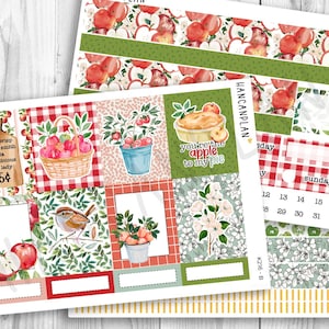 May include: A sticker sheet set featuring apple-themed illustrations, including a basket of red apples, a pie with the text you're apple to my pie, a bird, apple blossoms, and a wooden cutting board sign listing apple varieties with a 25 cent price.
