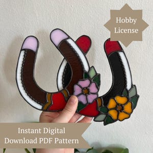 May include: Two stained glass horseshoe designs, one brown and one black, intertwined. Each horseshoe features a white border, red accents, and a floral design. The image includes the text "Instant Digital Download PDF Pattern" and "Hobby License".