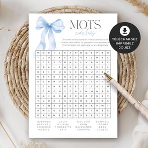 以下が含まれることがあります： ベビーをテーマにした単語検索パズルゲーム。水彩画の青いリボンと「MOTS cachés」の文字が上部にあります。印刷できるように設計されています。ペンが織り込まれた背景に置かれています。