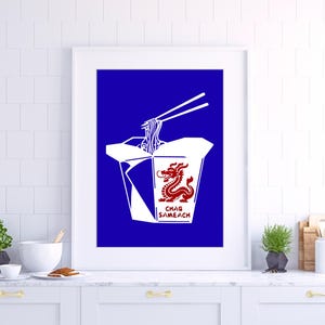 May include: A framed wall art print featuring a deep blue background with a white takeout container illustration. The container displays a red dragon graphic and the text CHAG SAMEACH, with white chopsticks lifting noodles from the top.