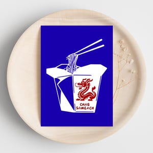 Puede incluir: Una impresión rectangular sobre fondo azul que muestra un recipiente de comida para llevar blanco con una ilustración de un dragón rojo y el texto CHAG SAMEACH. Un par de palillos blancos levantan fideos de la parte superior.