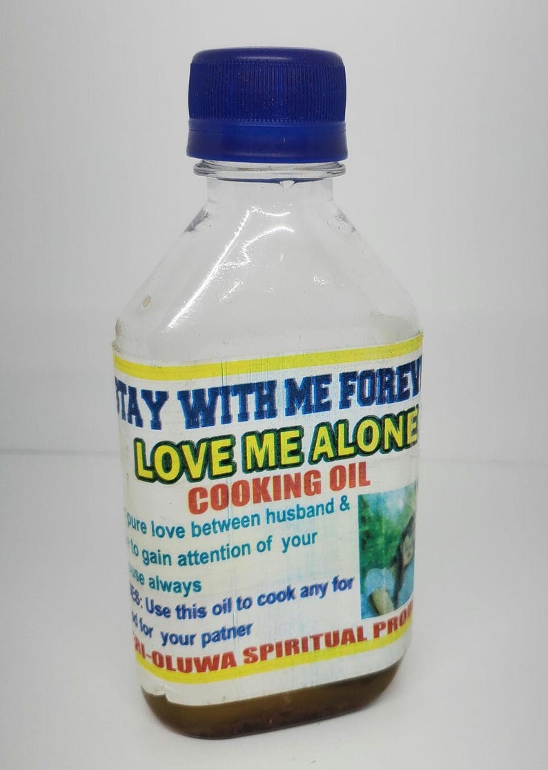 May include: A clear plastic bottle with a blue cap and a yellow label that reads "Stay With Me Forever Love Me Alone Cooking Oil". The label also includes the text "Pure love between husband & to gain attention of your Use this oil to cook any for your partner M-Oluwa Spiritual Products".