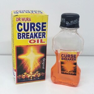 May include: A yellow box and a clear bottle of Dr. Wura Curse Breaker Oil. The box has the product name in large blue letters and a graphic of a bright light. The bottle contains orange liquid and has a black cap.