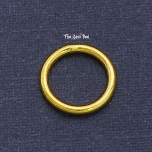 May include: Gold jump ring, a small circular ring used for connecting jewelry components.