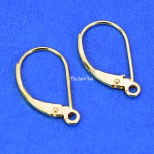 Puede incluir: Dos ganchos para pendientes de color dorado. Los ganchos son de metal y tienen un diseño simple y elegante.