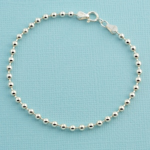 Puede incluir: Un brazalete de plata con cuentas y cierre de langosta.