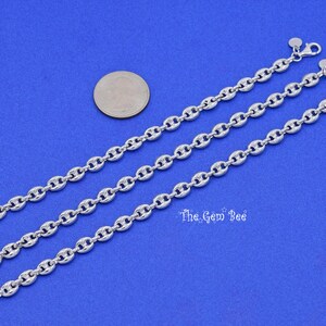 May include: Three silver-colored chain necklaces with a nautical link design are displayed on a blue background. A US quarter coin is next to the necklaces for size comparison. The Gem Bee text is visible.