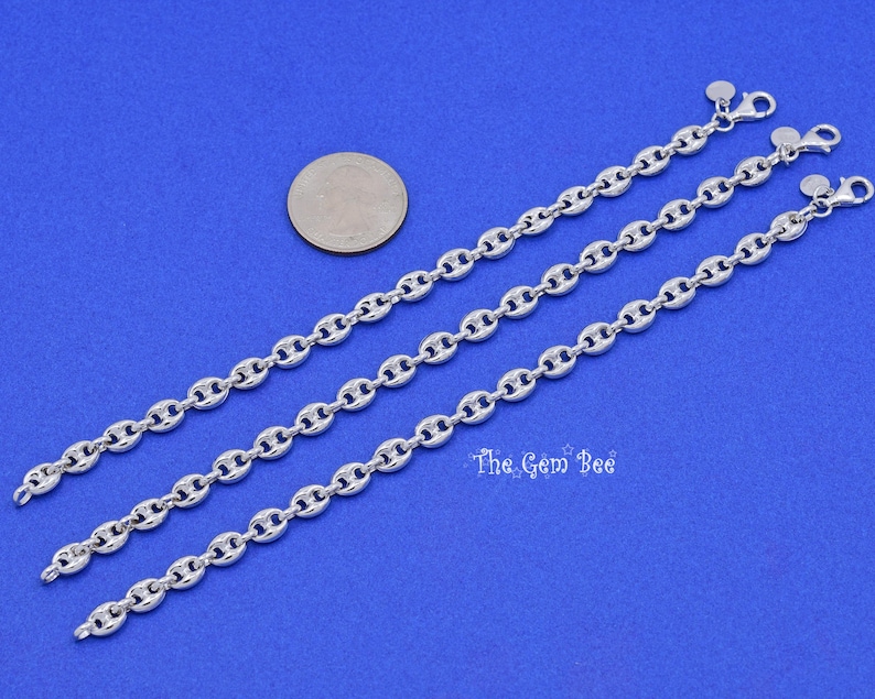 May include: Three silver-colored chain necklaces with a nautical link design are displayed on a blue background. A US quarter coin is next to the necklaces for size comparison. The Gem Bee text is visible.
