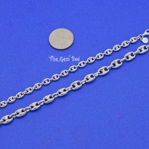 May include: Two silver-toned chain bracelets with a polished finish, featuring a distinctive oval link design. The bracelets are displayed on a blue background, with a coin for size comparison. The Gem Bee is printed on the background.