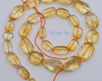 May include: A strand of translucent, oval-shaped yellow citrine beads arranged in a spiral pattern on an orange string. The beads vary slightly in size and clarity, featuring a smooth, polished finish. The text The Gem Bee is visible.