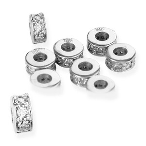 May include: Nine 18K gold spacers with a row of small diamonds around the edge. Each spacer has a small hole in the centre.