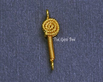 May include: A gold-toned metal connector charm featuring a circular, coiled rope-like top section attached to a straight, tightly wound cylindrical stem with small loops at both the top and bottom ends. The text The Gem Bee is visible.