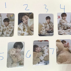 May include: Seven photo cards featuring a young man wearing a brown and white patterned pajama set. The man is posing in different ways, including holding a stuffed animal, playing a video game, and lying down. The cards are numbered 1 through 7.