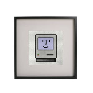 May include: A framed cross-stitch of a vintage Macintosh computer with a smiling face on the screen.