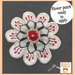 Peut inclure: Un patch en forme de fleur en sequins blancs, rouges et noirs avec le texte "Flower patch ready to apply" et "Hand-made" dans le coin inférieur droit. Le patch est prêt à être appliqué sur un tissu.