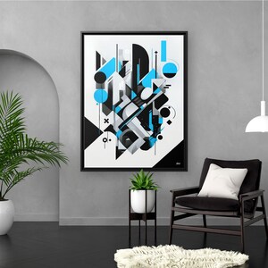 May include: Abstract art print in a black frame. The artwork features geometric shapes in black, white, and shades of blue. The print is displayed in a modern living room setting with plants and a black chair.
