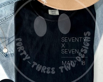 Puede incluir: Camiseta negra con un gráfico de cara sonriente blanca. El texto "FORTY-THREE TWO" está en el lado izquierdo del gráfico y "SEVENTY X SEVEN MATT. 18 OF DESIGNS" está en el lado derecho del gráfico.