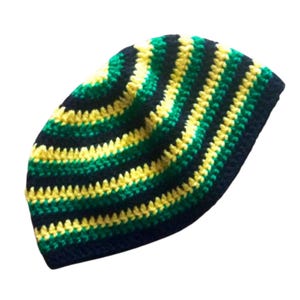 Peut inclure: Un bonnet au crochet rayé jaune, vert et bleu marine. Le bonnet est de style ajusté, probablement pour la chaleur et la mode. Le fil semble doux et les points sont uniformes. Fait à la main.
