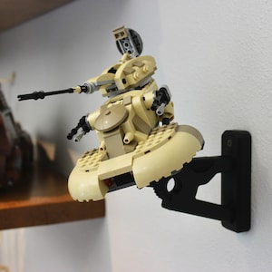 May include: A beige and brown Lego Star Wars model of a speeder bike mounted on a black wall mount.