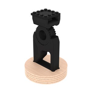 May include: A black 3D printed phone stand with a gear design and a wooden base.