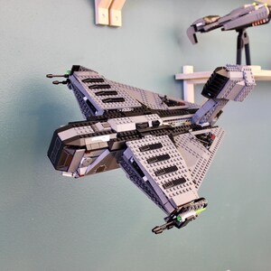 Puede incluir: Una nave espacial Lego gris y negra con un diseño detallado. La nave espacial tiene una cabina, alas y una cola.