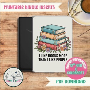 May include: Kindle Paperwhite case featuring a colourful illustration of stacked books with floral decorations. The text reads "I like books more than I like people". The case is for the 12th Gen Kindle.