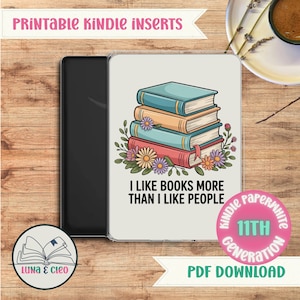 May include: A Kindle Paperwhite case with a design featuring a stack of books with floral accents and the text "I LIKE BOOKS MORE THAN I LIKE PEOPLE." The case is black and white, with the words "PRINTABLE KINDLE INSERTS" at the top.