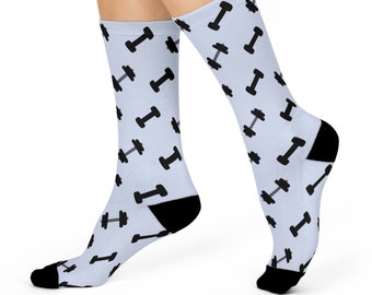 Könnte beinhalten: Ein Paar hellblaue Socken mit einem schwarzen Hantel-Muster. Die Socken werden an den Füßen eines Models gezeigt.