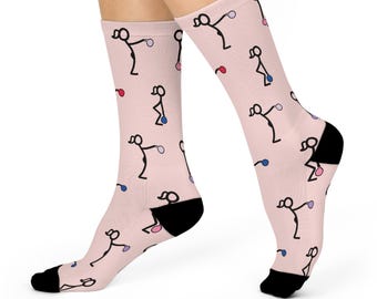 Könnte beinhalten: Ein Paar rosa Socken mit einem Muster aus Strichmännchen, die Gewichte halten. Die Socken haben schwarze Zehen und Fersen.