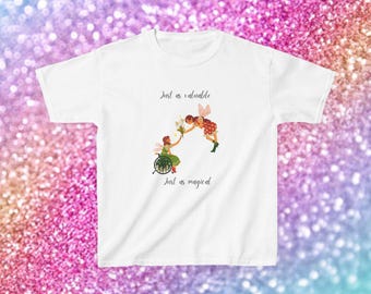 May include: White t-shirt with an illustration of two fairies, one in a wheelchair, exchanging flowers. The text "Just as valuable, Just as magical" is printed above and below the illustration. The shirt has short sleeves.