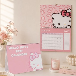 Może przedstawiać: Różowy kalendarz Hello Kitty 2027 obejmujący wersję biurkową z białą grafiką postaci oraz wersję ścienną z kalendarzem na styczeń 2027 roku, tłem w różowe cętki oraz ilustracją Hello Kitty w górnej części strony.
