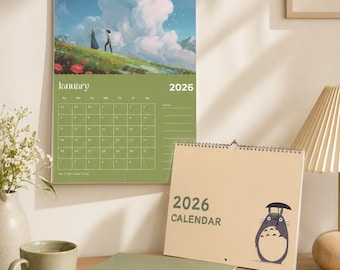 Könnte beinhalten: Ein Wandkalender für 2026 mit einer hängenden Seite, die eine Anime-Landschaft mit zwei Figuren auf einem grasbewachsenen Hügel unter großen Wolken zeigt, sowie einer zweiten Kalenderseite mit dem Text 2026 CALENDAR und einer Cartoon-Figur mit Regenschirm.