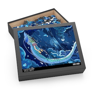 May include: A 252 piece jigsaw puzzle featuring a blue and green dragon with a girl riding on its back. The puzzle is set against a dark blue background with white clouds. The box is black with the text "11x14 Puzzle 252 pcs Ages 9+" printed on the front.