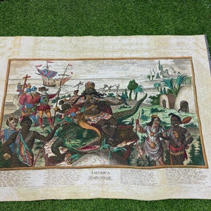 May include: A vintage tapestry depicting a scene from the colonization of America. The tapestry features a large crocodile with a Native American figure riding on its back. Other figures include European explorers, Native Americans, and a ship in the background. The tapestry is framed with a white border and includes the text "AMERICA. AMERICA."