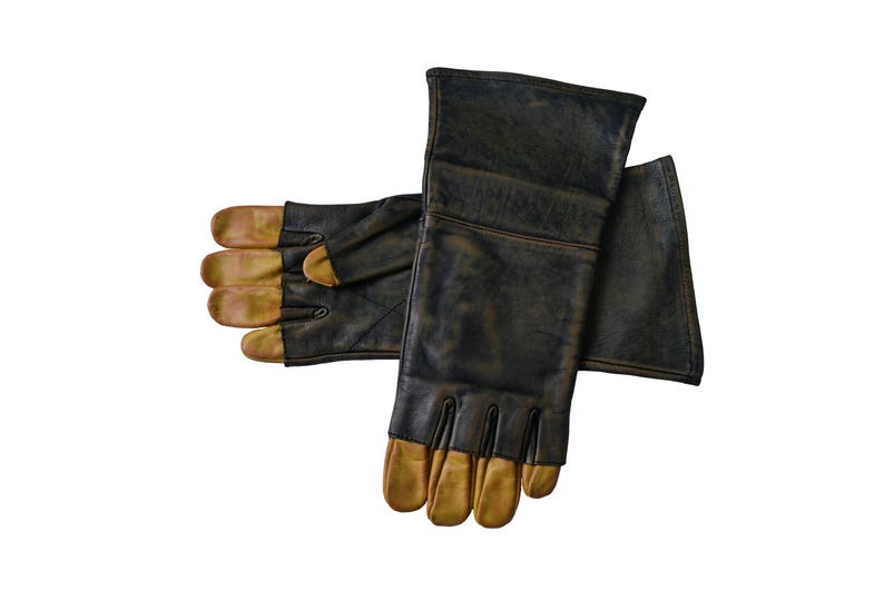 May include: A pair of black leather gloves with brown leather fingertips. The gloves have a long cuff and are designed for protection.