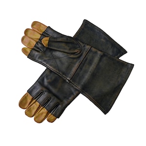 May include: A pair of black leather gloves with gold-colored fingertips. The gloves are folded in half, with the fingertips of one glove visible.