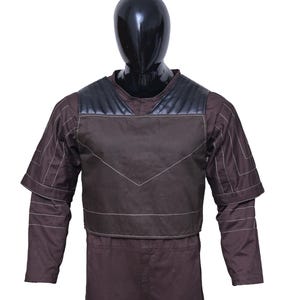 May include: A brown jumpsuit with a black and brown vest. The vest has a quilted design and white stitching.