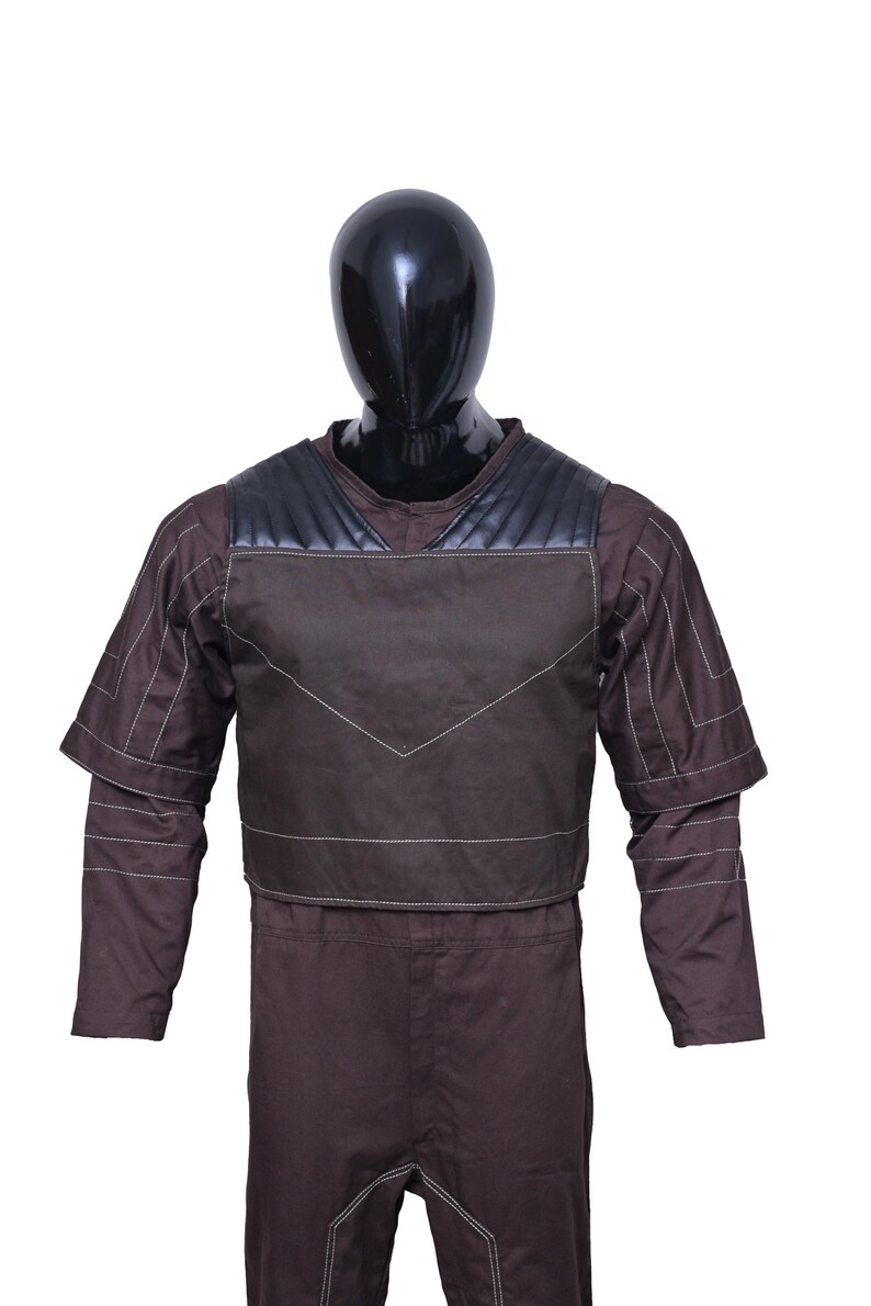 May include: A brown jumpsuit with a black and brown vest. The vest has a quilted design and white stitching.