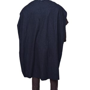 May include: A dark blue hooded cloak with a long, flowing design. The cloak is worn over brown pants.