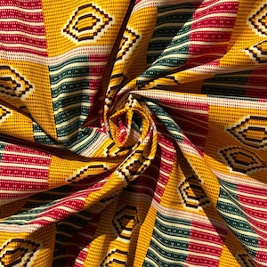 May include: Close-up of a vibrant fabric with a repeating geometric pattern. The design features a mix of yellow, red, green, and white stripes and diamond shapes. The fabric is folded, creating a textured appearance.