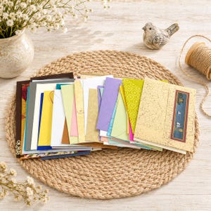 Puede incluir: Una gran colección de sobres rectangulares variados en diversos colores y patrones, incluyendo amarillo, azul, rosa, morado y verde sólidos, junto a sobres color crema texturizados con un pequeño gráfico rectangular de velero.