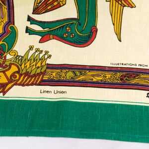Puede incluir: Un tejido de mezcla de lino color crema con un borde verde vibrante e intrincadas ilustraciones de estilo celta. El dise&ntilde;o incluye una criatura verde estilizada, detalles en amarillo y rojo, y el texto "ILLUSTRATIONS FROM THE BOOK OF" y "Fingal".
