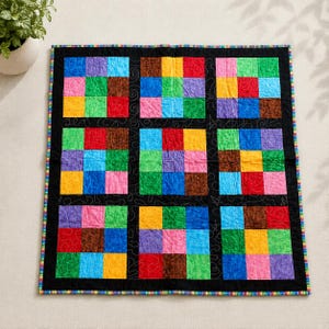 May include: A square patchwork quilt featuring a grid of nine blocks, each containing nine smaller multicoloured squares in shades of red, blue, green, yellow, purple, pink, and brown. The blocks are separated by black sashing with swirl stitching.