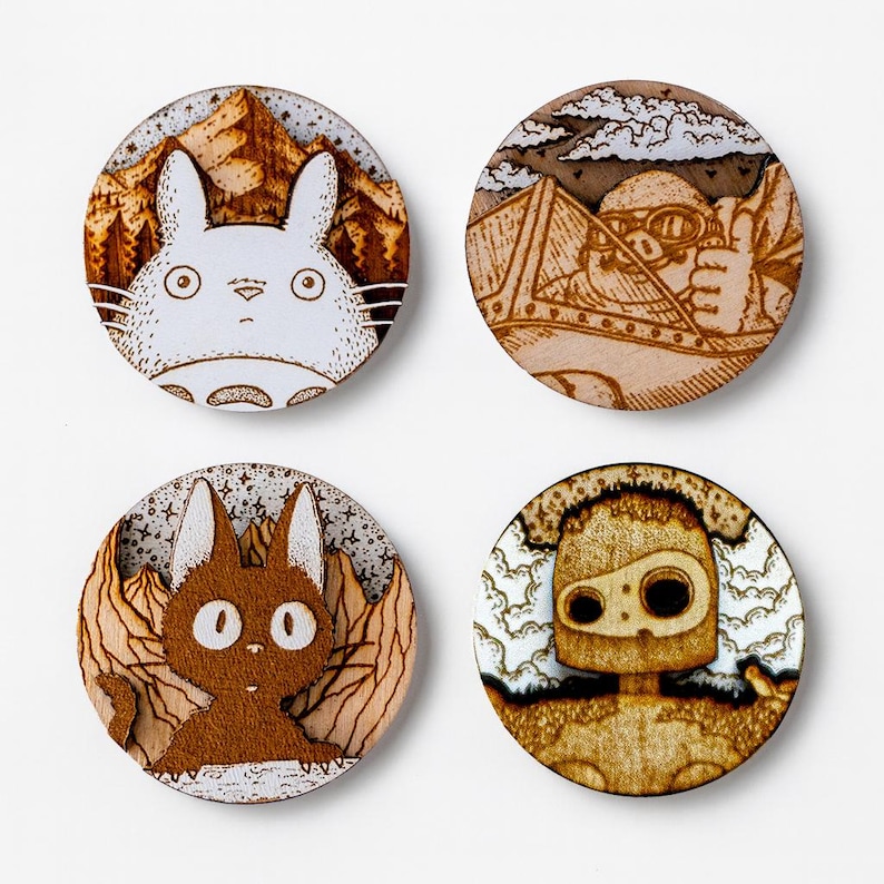 Set of four round wooden magnets inspired by Studio Ghibli films. Features Totoro, Porco Rosso, Jiji from Kiki’s Delivery Service, and the guardian robot from Castle in the Sky. Each magnet measures 5 cm in diameter and is handmade from three layers of plywood and MDF with detailed engravings in warm tones. Perfect as home decor or a thoughtful gift for anime and Studio Ghibli fans.