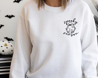 May include: White sweatshirt with a black graphic of a ghost and the text "spooky season".