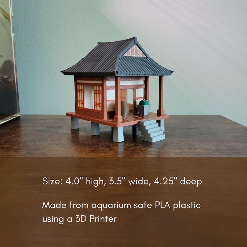May include: A miniature Japanese-style house, 4.0 inches high, 3.5 inches wide, and 4.25 inches deep. The model features a dark roof, brown walls, and a raised platform. It includes a small staircase and is made from aquarium-safe PLA plastic using a 3D printer.