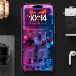 Puede incluir: Una funda transparente para teléfono con un diseño rosa y azul que parece una consola de videojuegos portátil vintage. La pantalla muestra la hora "10:14" y la fecha "Martes, 6 de septiembre".