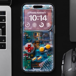 May include: Clear phone case with a retro video game controller design. The phone screen displays the time as 10:14 on Tuesday, September 6. A laptop and mouse are visible in the background.